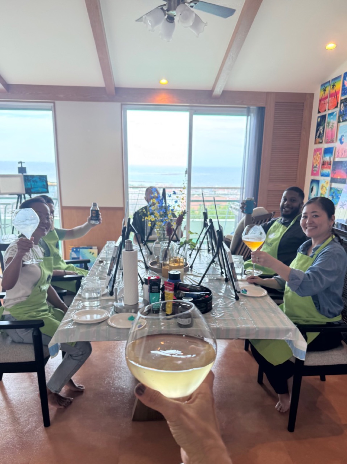 Private session guests raising glasses around the painting table