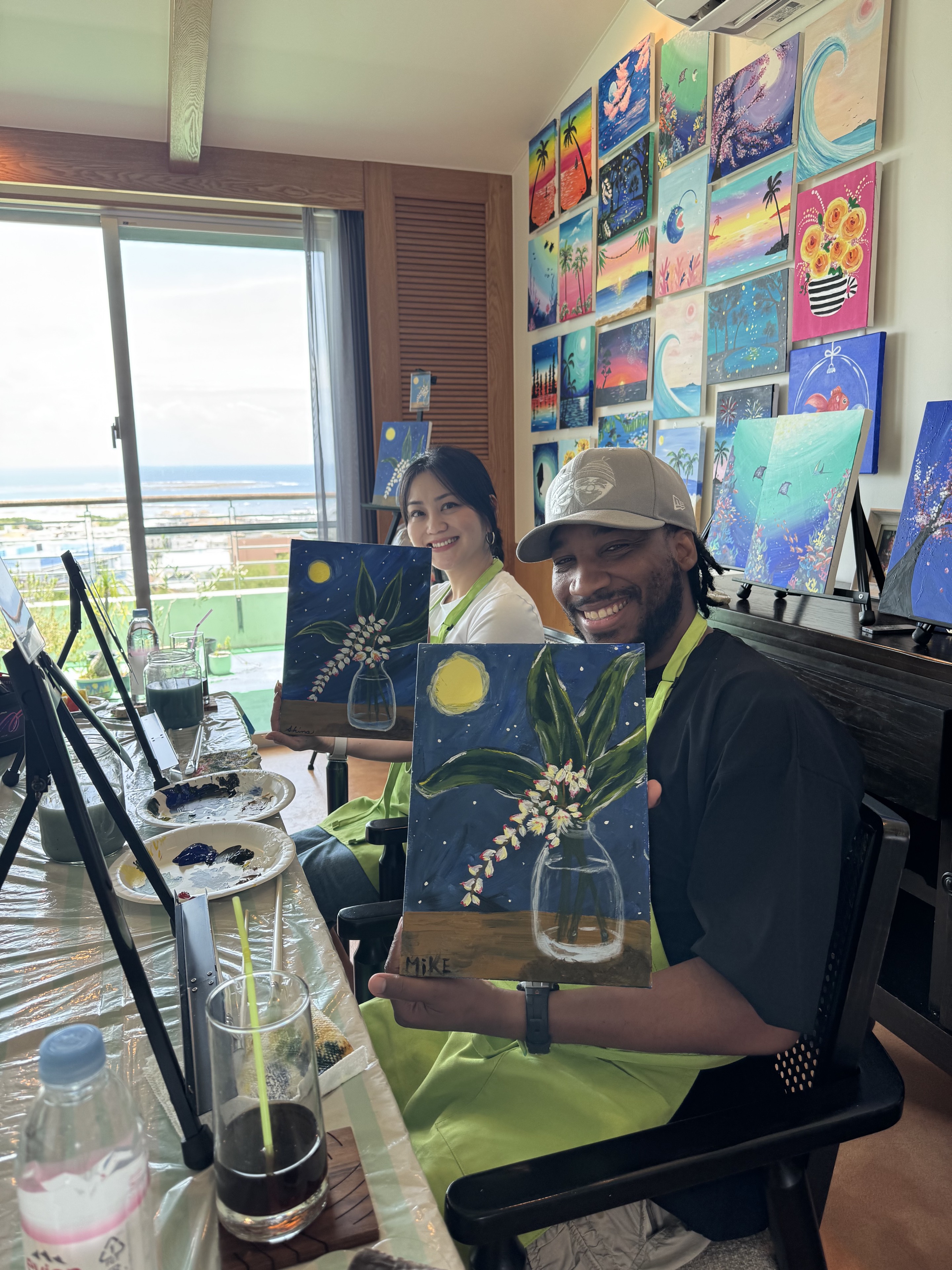 Pinto Beetle guests smiling with finished moonlit getto paintings in the ocean-view studio