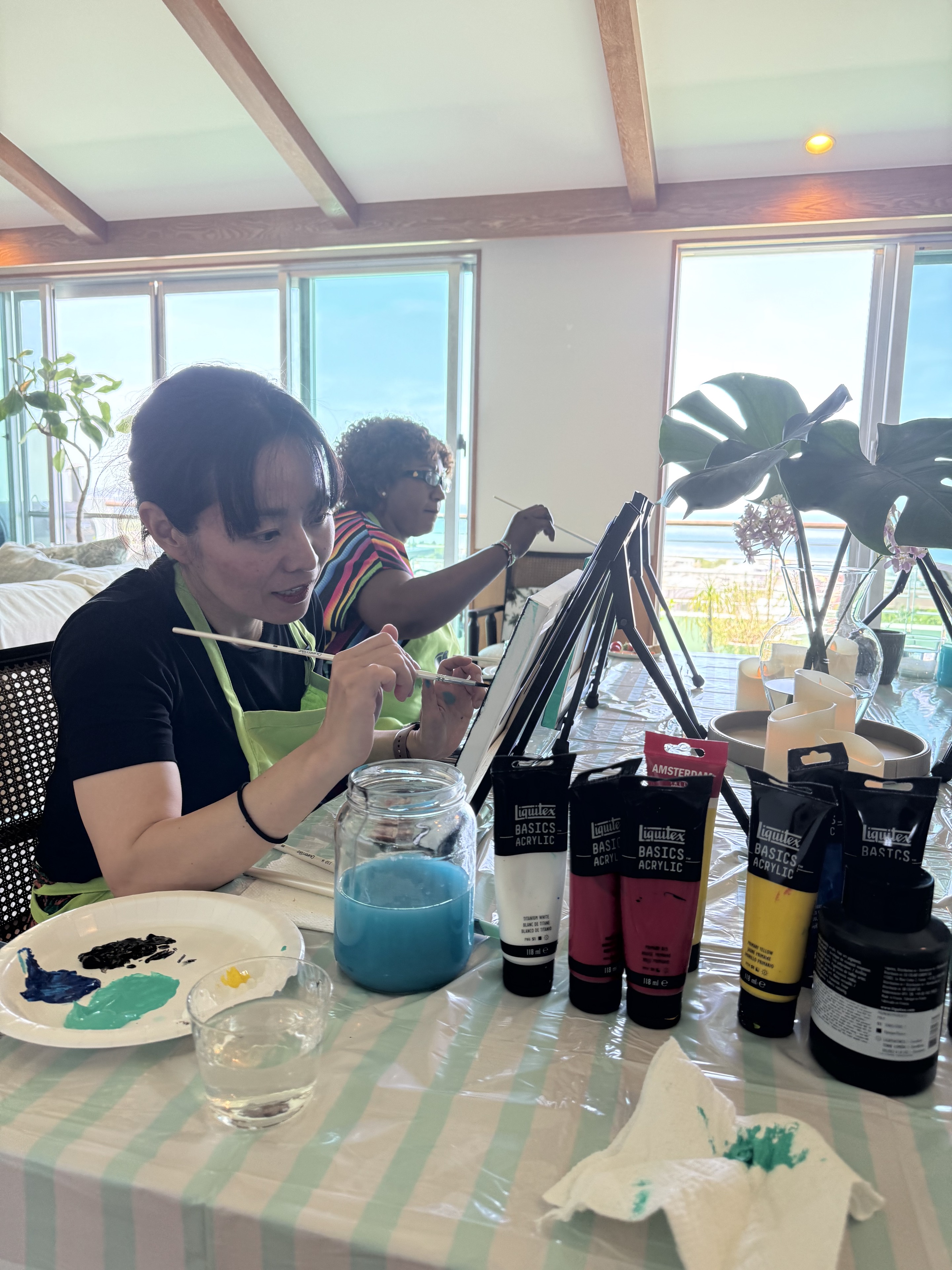 Pinto Beetle guests painting together by the ocean-view windows