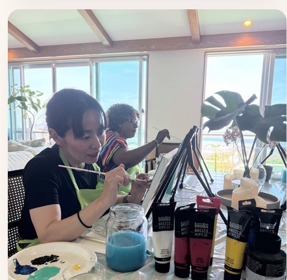 Pinto Beetle guests painting together in the ocean-view studio