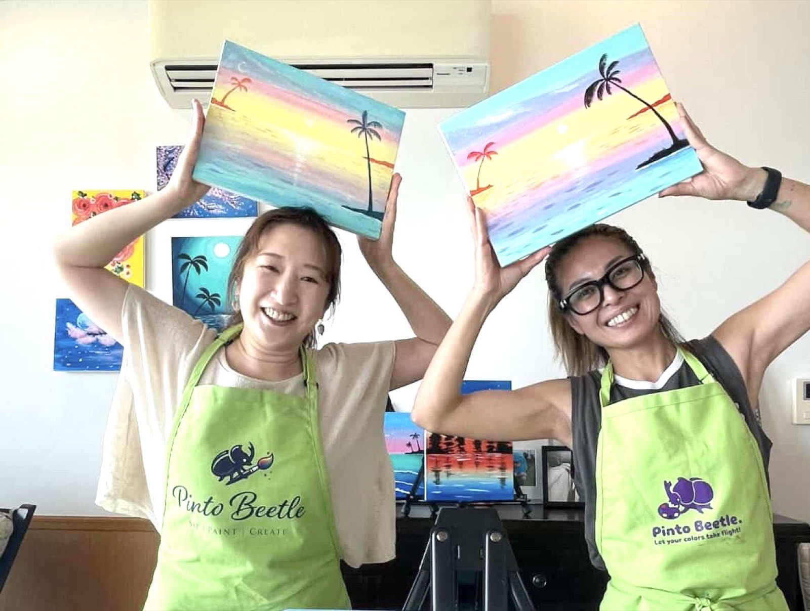 Friends smiling with finished pastel sunset paintings