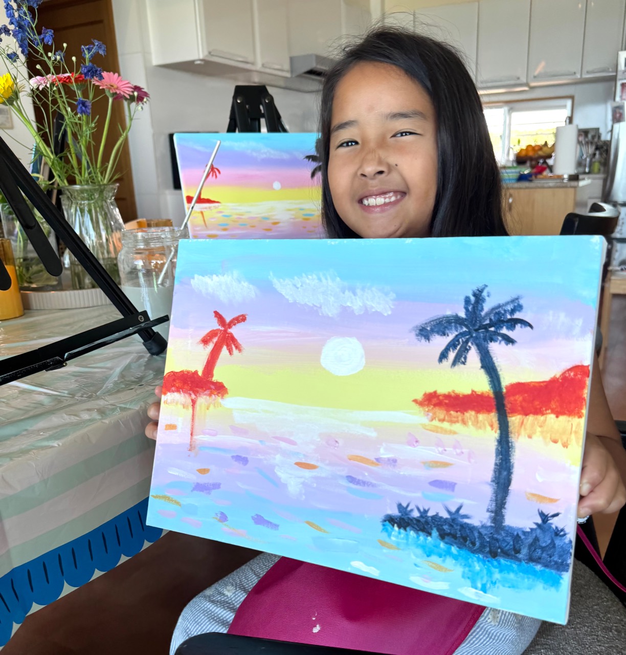 Young guest smiling with a finished painting